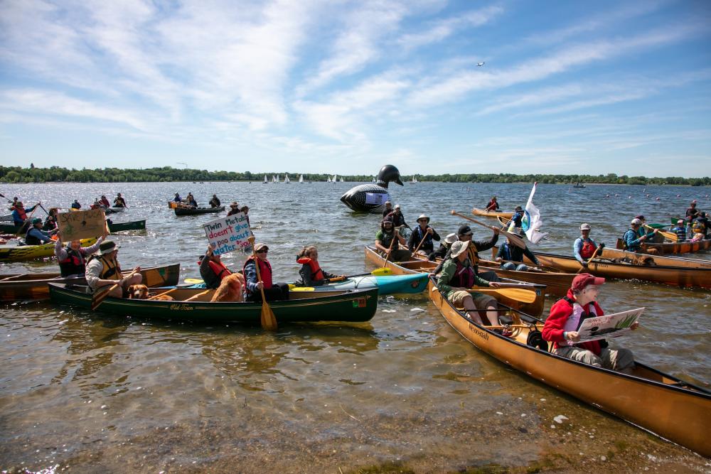 People in canoes on lake with floating loan