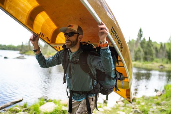 Alex Falconer carrying a canoe