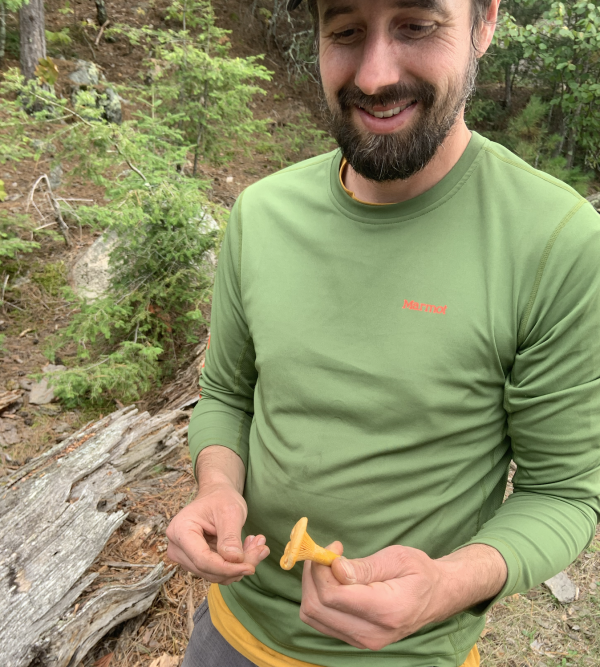 Thompson holding a foraged mushroom 