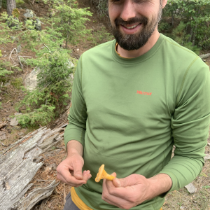 Thompson holding a foraged mushroom 