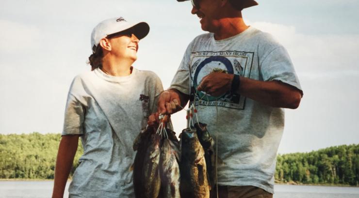 Photo of 2 people holding a bunch of fish looking at eachother