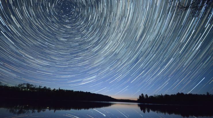 long exposure photo of night sky with stars swirling in a circle