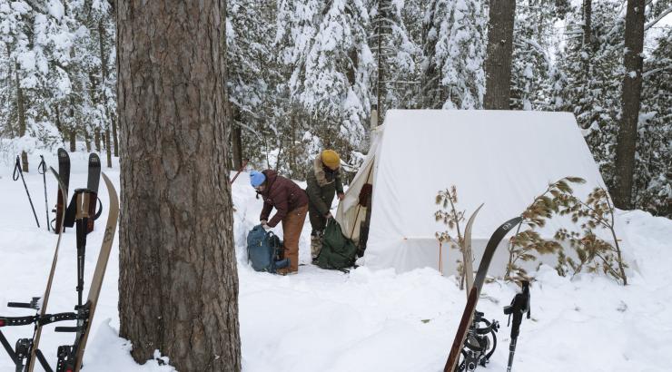 Two people pack their gear in winter bags. Photo: Nate Ptacek