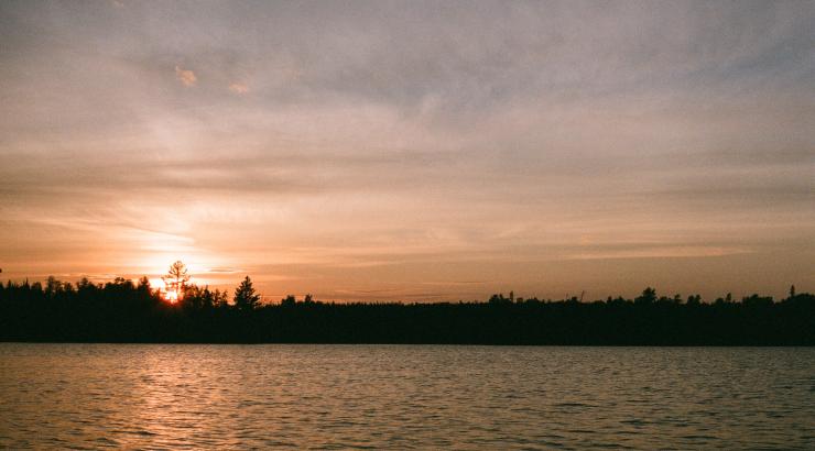photo of boundary waters sunset with a tree silhouette skyline