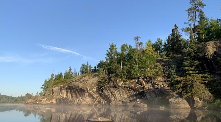 Clif rocks reflecting onto blue water