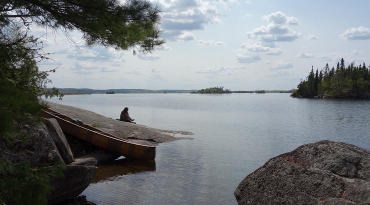 Photo of person sitting on rock overlooking Boundary Waters