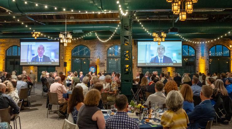 People enjoying dinner and watching presentation 