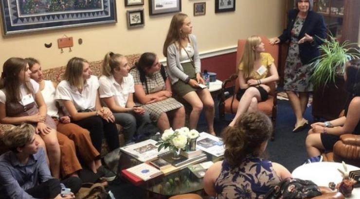 Photo of group of kids sitting down looking at Rep. Betty McCollum speaking to them