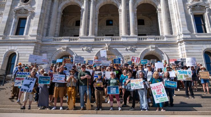 Group of people with signs on steps of the mn capitol 
