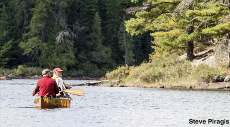 Two anglers sit in a canoe in the Boundary Waters