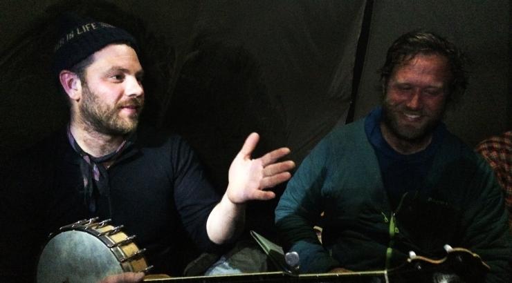 Ben Weaver holding banjo sitting in tent with Dave Freeman