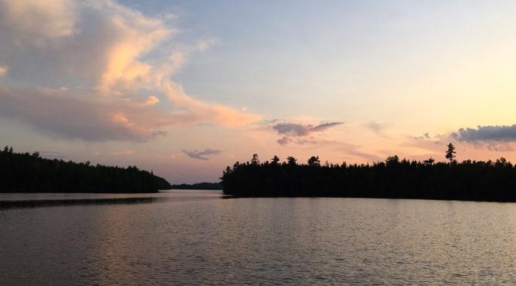 Photo of Boundary Waters sunset with tree silhouettes on the horizon