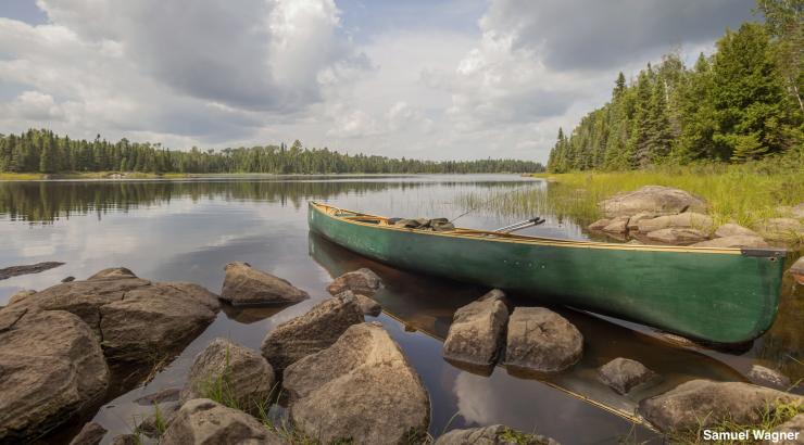 A picture of a canoe resting on the shores of a Boundary Waters lake. (Photo Credit: Samuel Wagner)