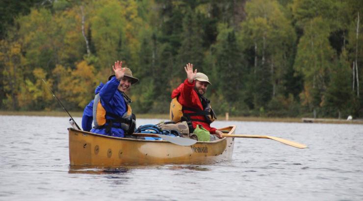 Dave and Amy Freeman waving in a canoe