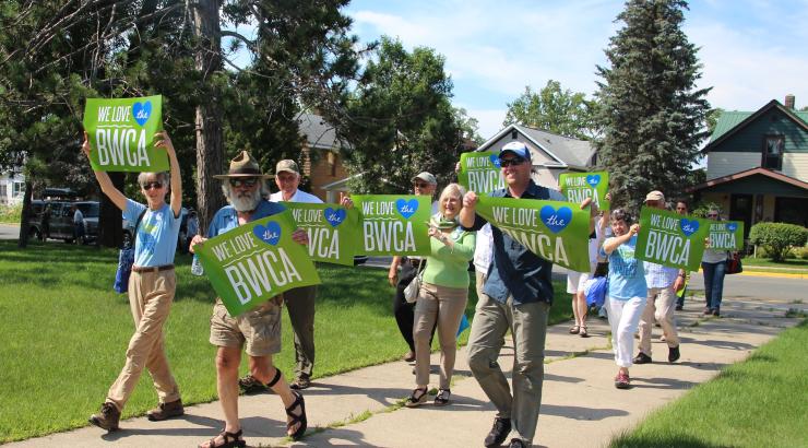 Photo of group of people walking with "We love the BWCA" sign