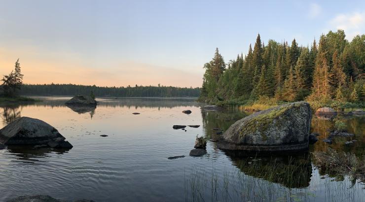 Photo of glassy water with Boundary Waters sun rise over it