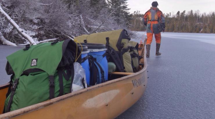 Photo of Amy Freeman pulling a canoe full of gear