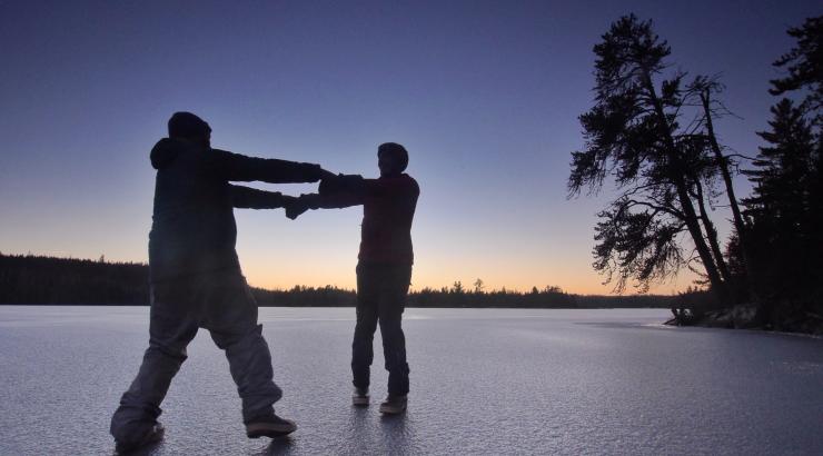 Photo of Amy and Dave Freeman dancing on a frozen lake together at sunset 