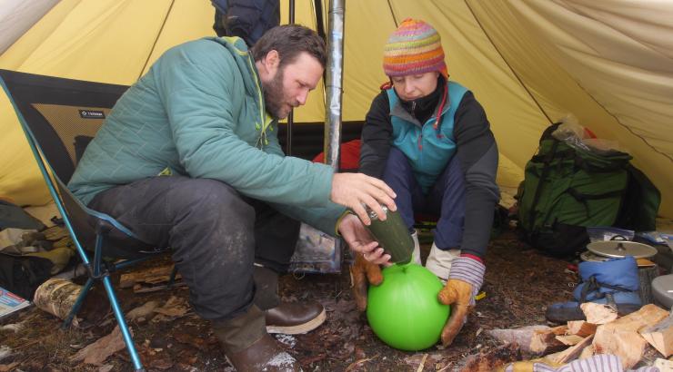 Photo of Amy and Dave Freeman making luminaries under a tarp