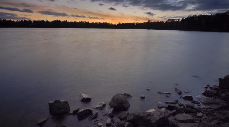 Photo of dark sky and dark water as the sun sets over the Boundary Waters