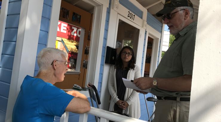 Photo of volunteer Tom Bose leaning on railing and delivering petitions at Minnesota State Fair 2017