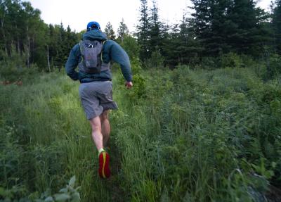 An image of Campaign to Save the Boundary Waters Campaign Manager Alex Falconer running through a clearing in the woods during his trail run of the Boundary Waters Traverse.