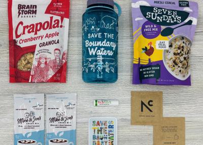 Products from the Boundary Waters Box, including Save the BWCA water bottle, sticker, and local camp foods