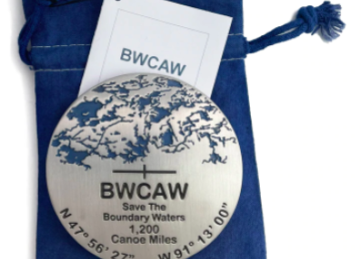BWCAW Medallion resting on top of a navy blue pouch