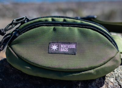 Photo of green fanny pack with Northside Bags logo on front. 