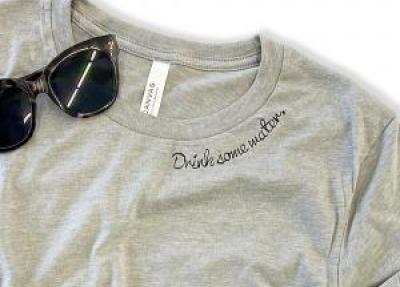 Grey t-shirt with black text along collar that says "drink some water"
