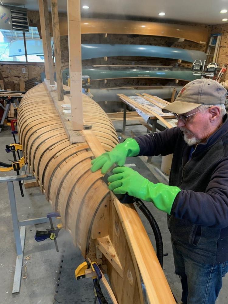 Tacking cedar planks to the ribs to shape the hull