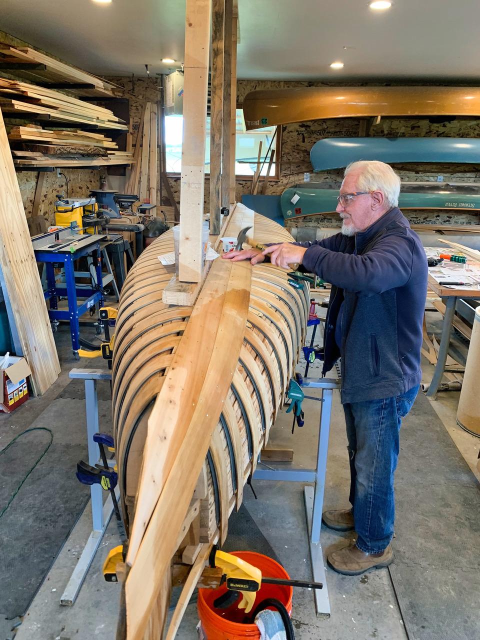 Tacking cedar planks to the ribs to shape the hull