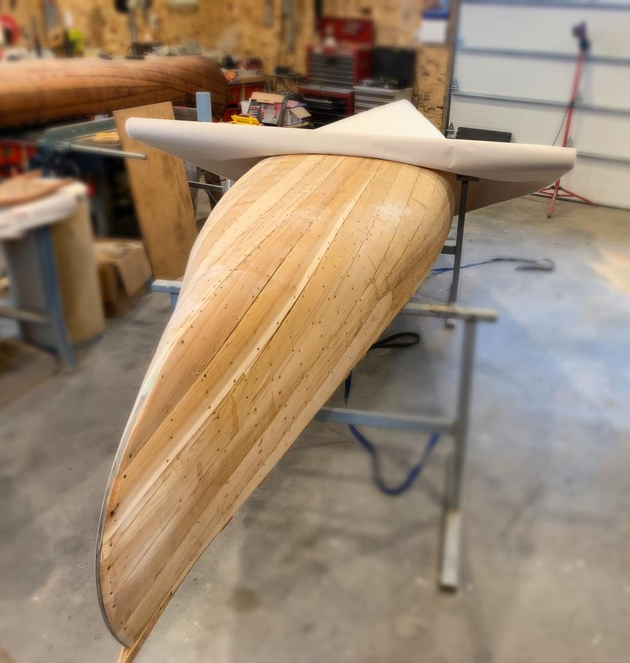 Stretching cotton canvas tightly over the planked hull