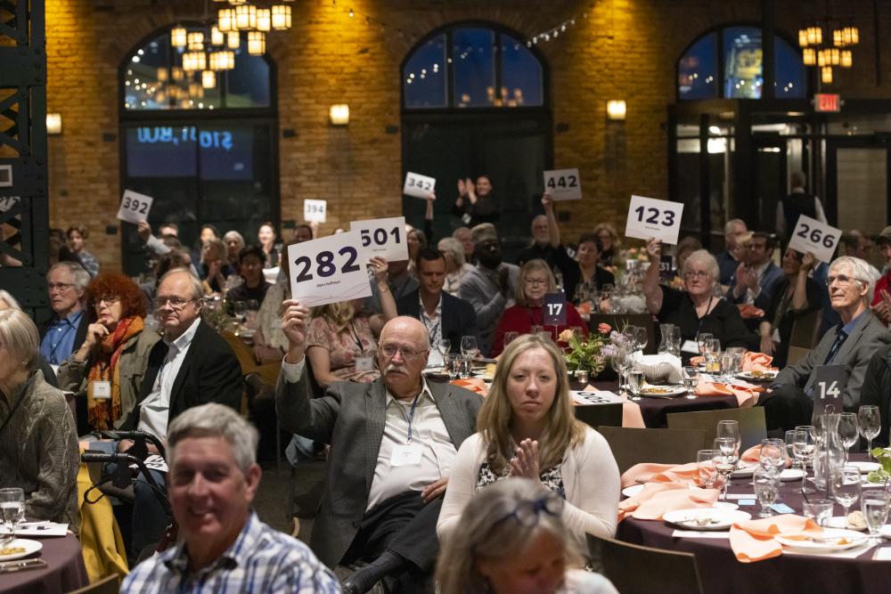 People holding up bid numbers