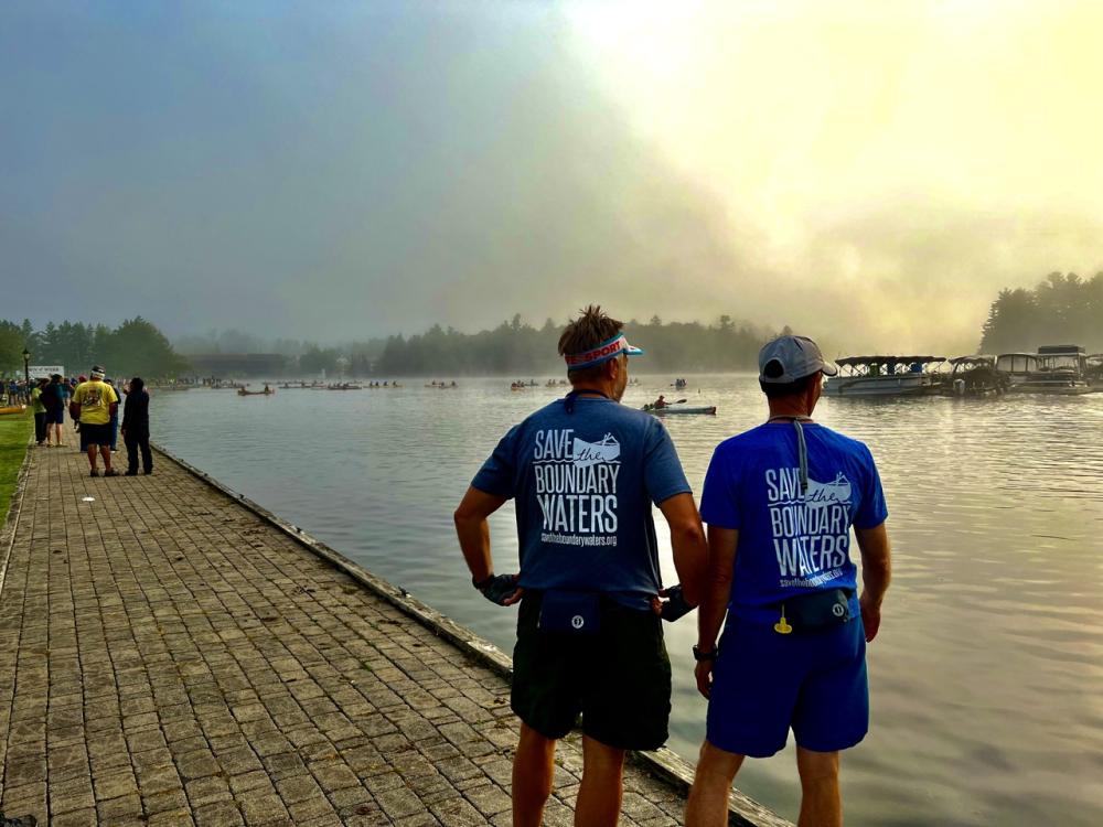 Two men in Save the Boundary Waters shirts looking at water