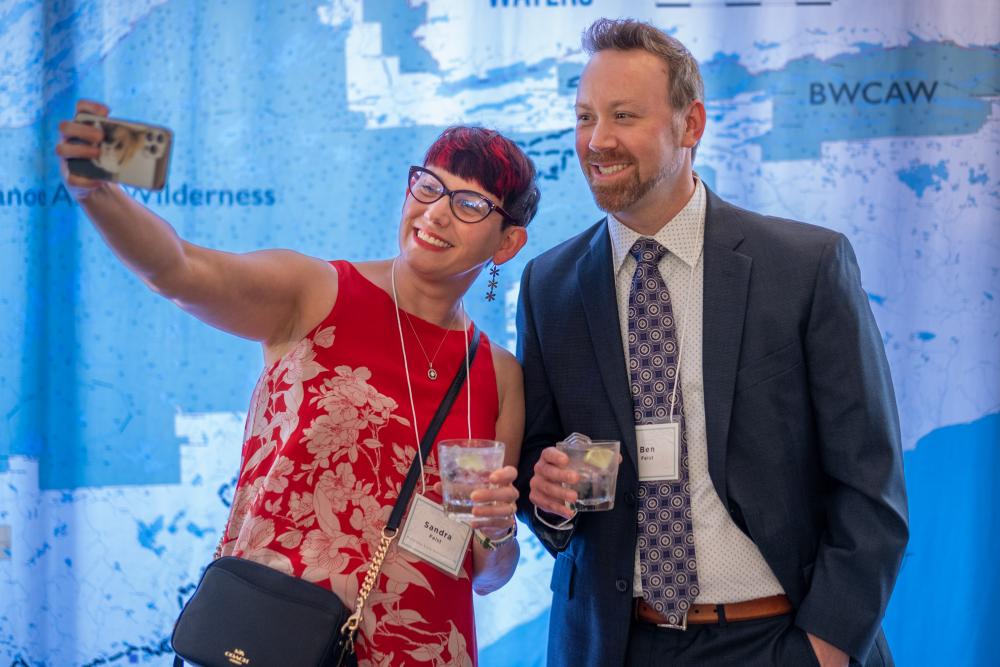 Two people taking selfie in front of map