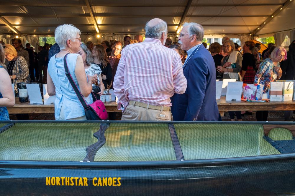 People standing in front of raffle canoe