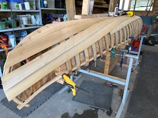 Tacking cedar planks to the ribs to shape the hull