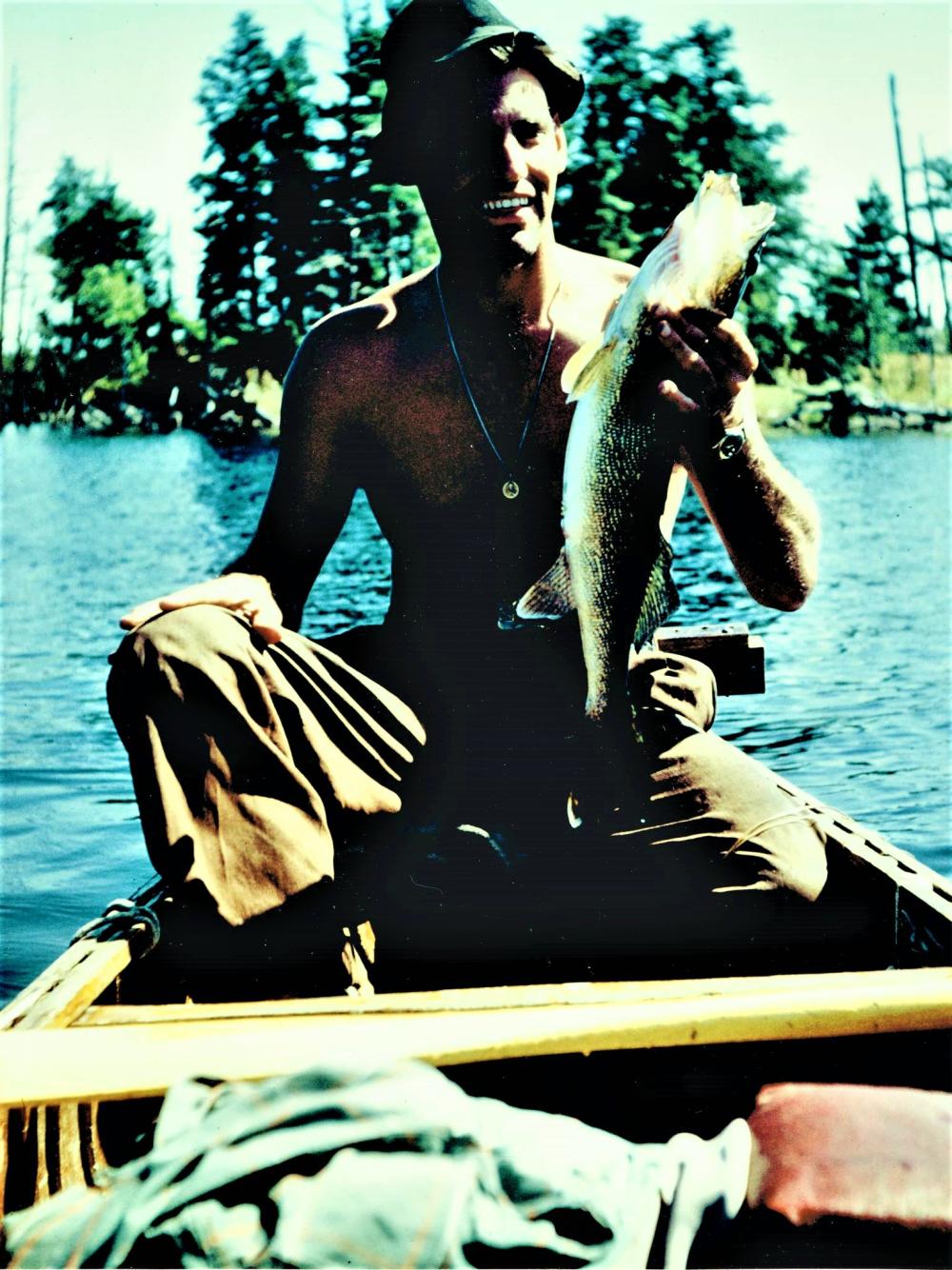 Man in canoe holding a fish