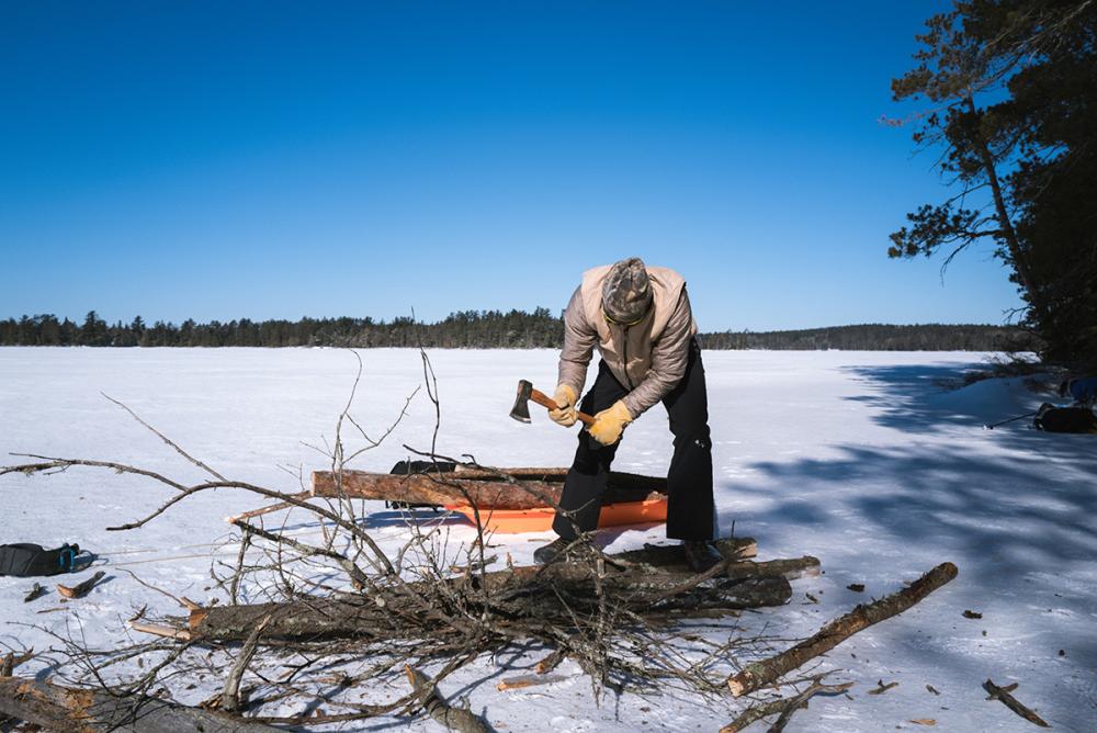 Wood is processed with an axe near camp for the woodstove.