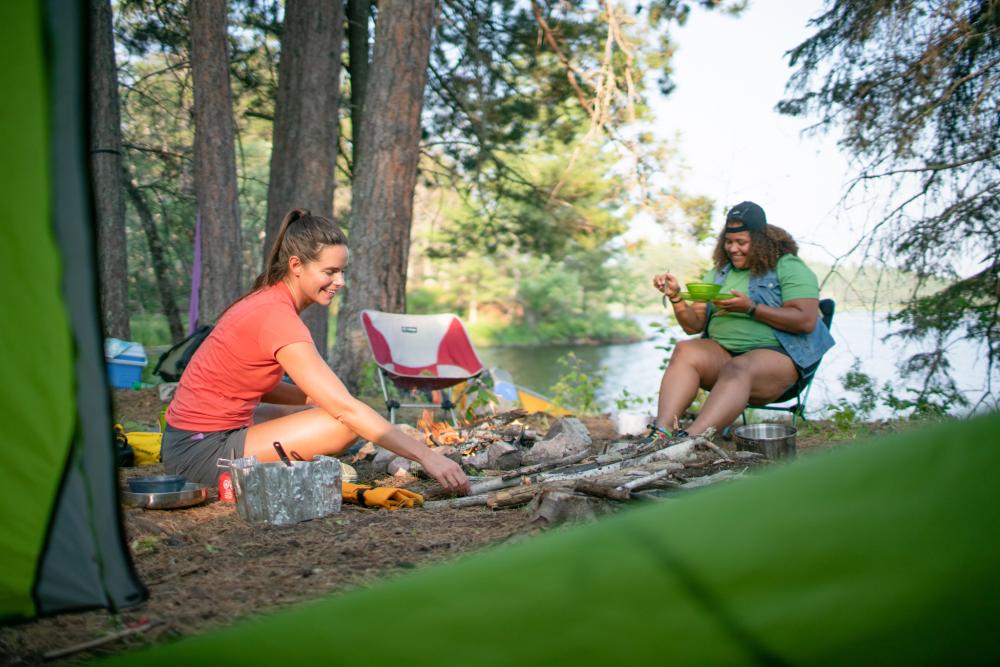 two people sitting at campsite