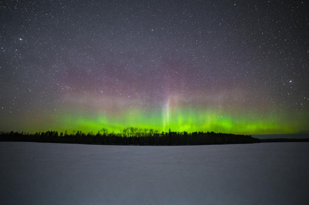The northern lights peek over the horizon during a winter night in the Boundary Waters