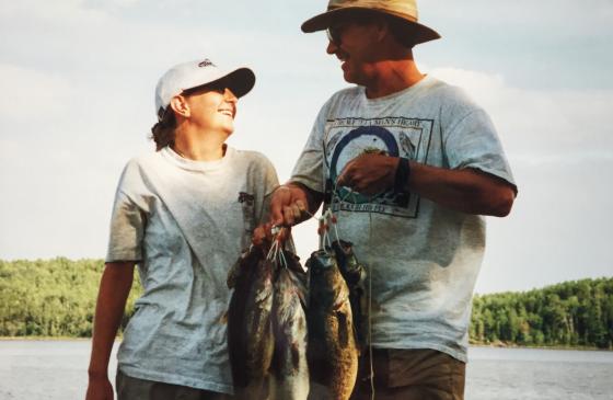 Photo of 2 people holding a bunch of fish looking at eachother