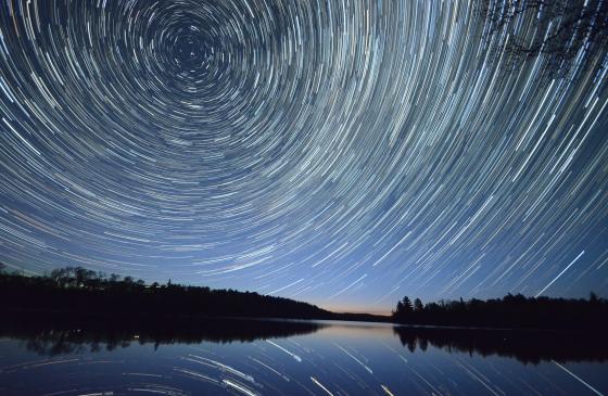 long exposure photo of night sky with stars swirling in a circle