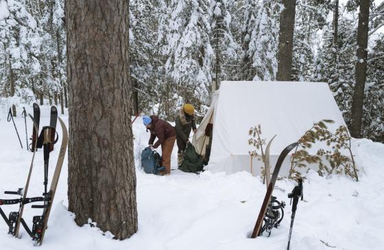 Two people pack their gear in winter bags. Photo: Nate Ptacek