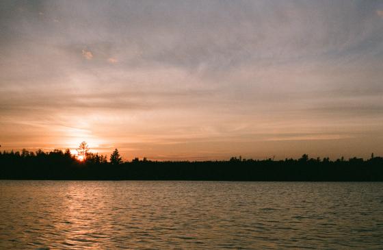 photo of boundary waters sunset with a tree silhouette skyline