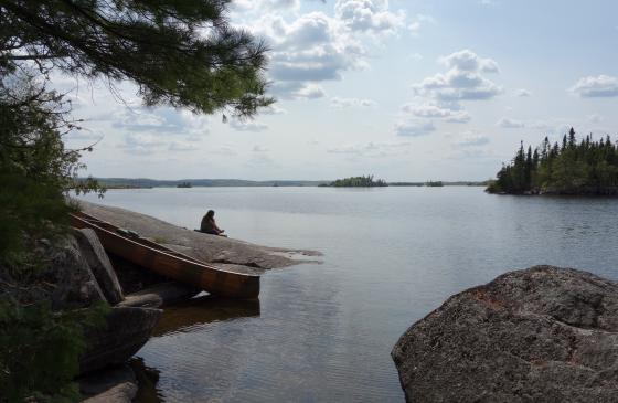 Photo of someone sitting on rock over looking the Boundary Waters