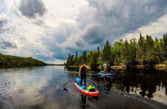 Image of 2 people paddle boarding through channel in Boundary Waters