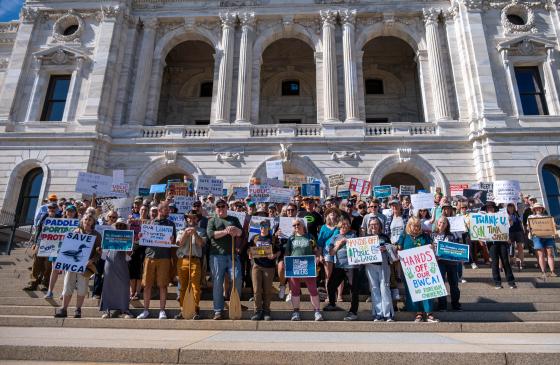 Group of people with signs on steps of the mn capitol 