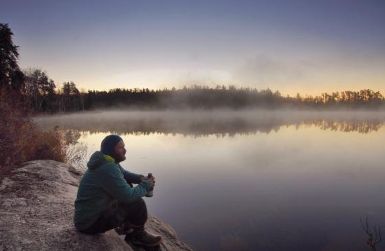 Dave Freeman sips a warm drink on a foggy morning in the Boundary Waters